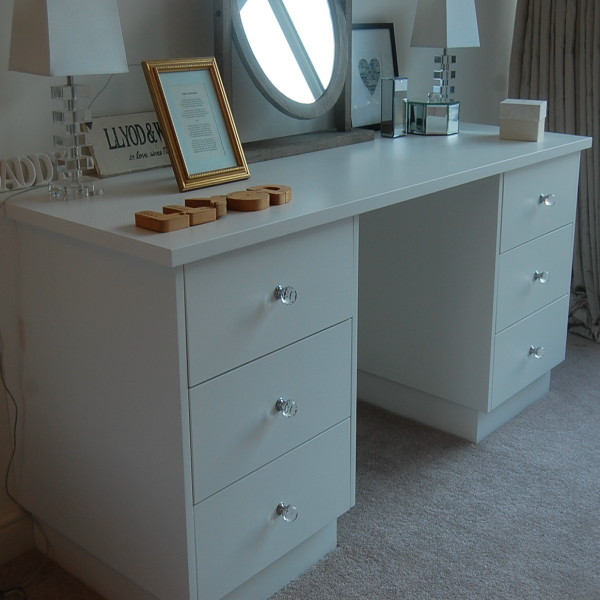 white spray painted dressing table in bedroom with crystal knobs to drawers