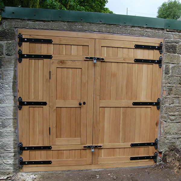 solid oak garage door with black ironmongery and small access door 